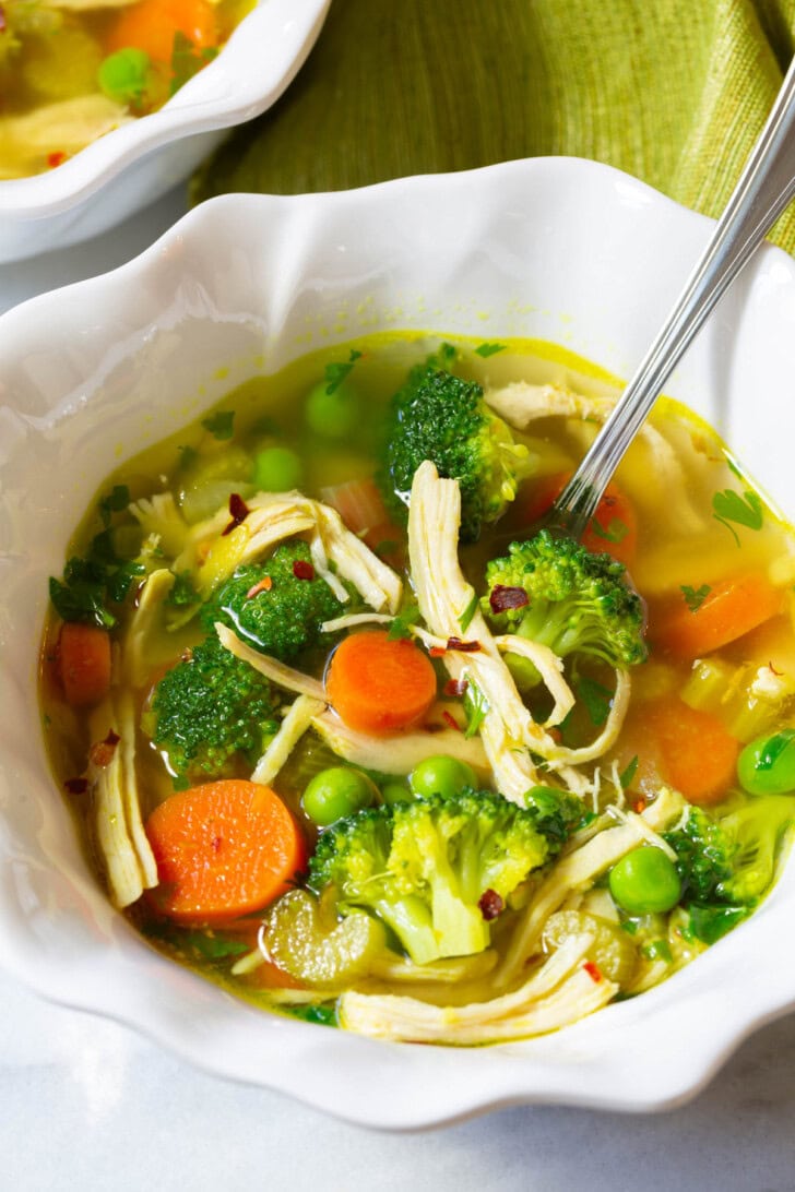 Detox Soup #ASpicyPerspective #ChickenSoup #DetoxSoup #ChickenSoupRecipe #ChickenDetoxSoup #Cleanse #Detox #Paleo #GlutenFree #DairyFree #Soup Chicken detox soup in a bowl with a spoon.