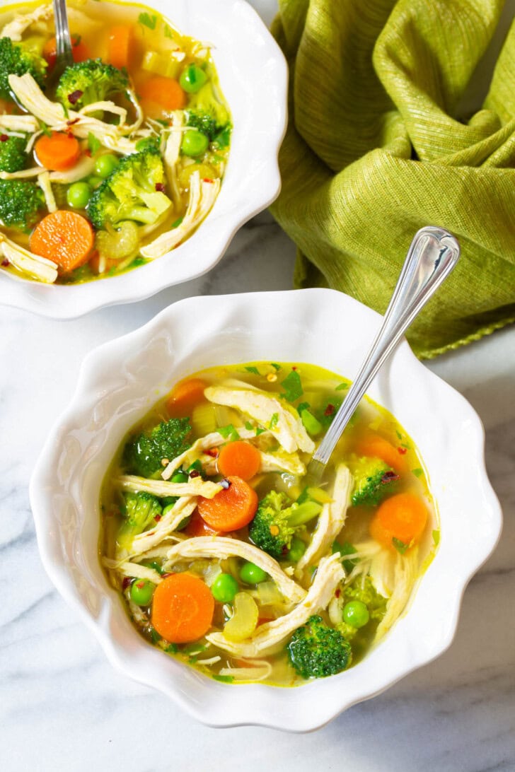 Detox Soup #ASpicyPerspective #ChickenSoup #DetoxSoup #ChickenSoupRecipe #ChickenDetoxSoup #Cleanse #Detox #Paleo #GlutenFree #DairyFree #Soup Two white bowls filled with chicken detox soup.