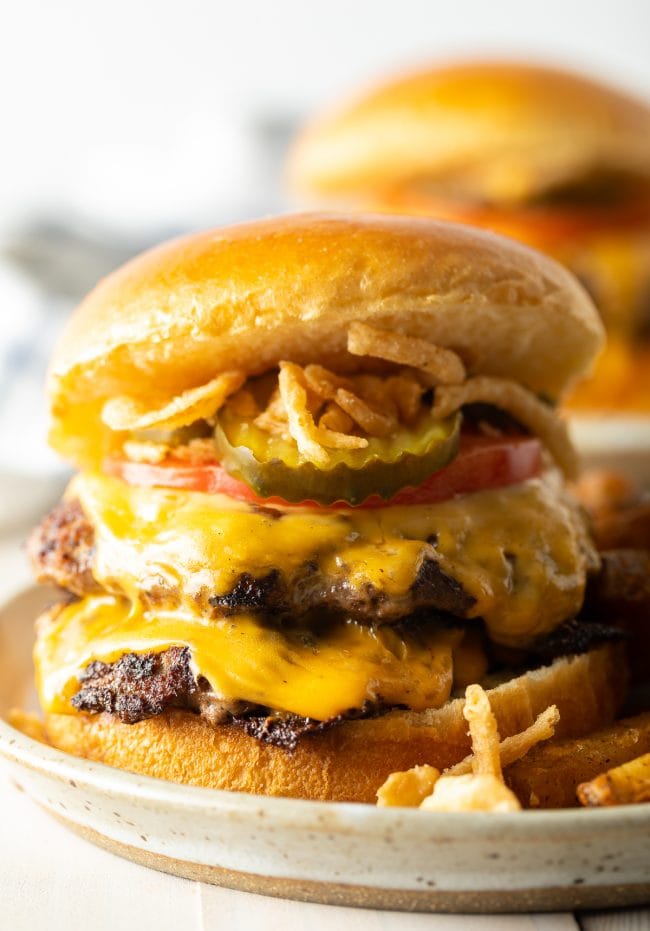 Hamburger with two patties and cheese topped with fried onions.