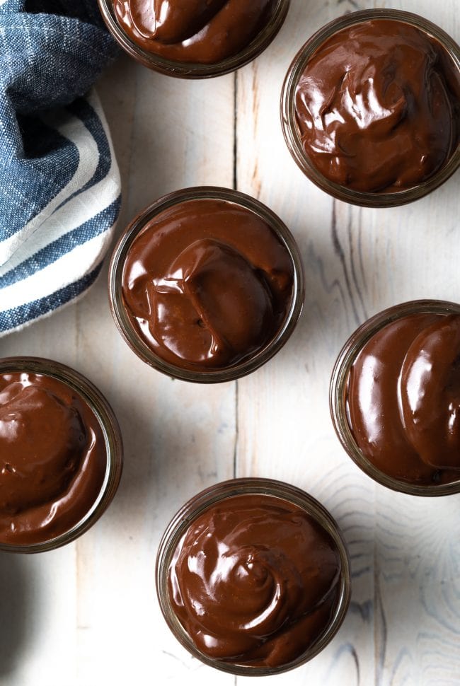 Overhead shot of chocolate pudding in jars.