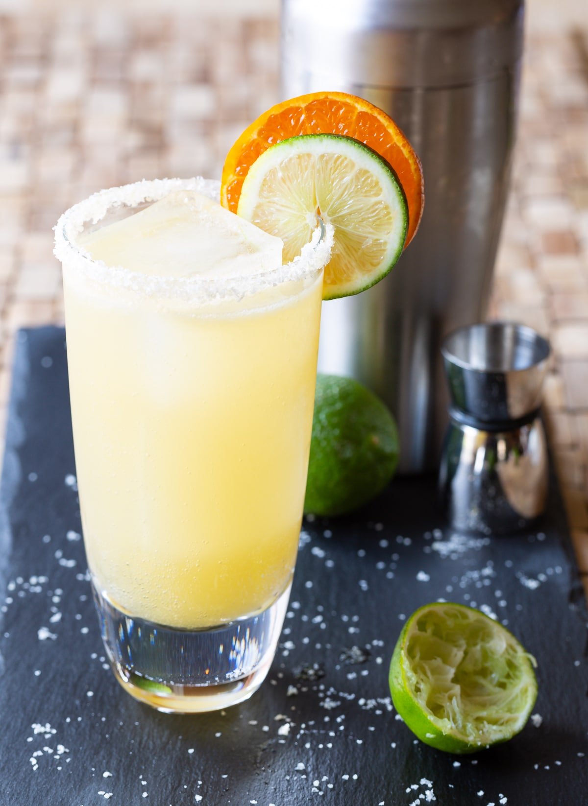How to Make a Margarita #ASpicyPerspective #Margarita #MargaritaRecipe #BestMargaritaRecipe #HowtoMakeaMargarita #Drink #Tequila #CincodeMayo #ClassicMargarita #Margaritas #Mexican #Cocktails Margarita in a glass with salt on the rim and garnished with citrus slices.