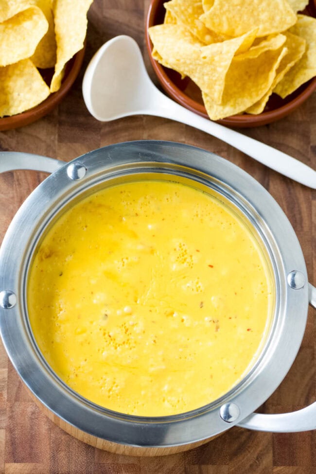 Cheese sauce makes or breaks any nacho recipe. The Best Queso recipe is easy and flavorful, with sharp and smoky notes. Start dipping those tortilla chips! #ASpicyPerspective #queso #cheese #dip Homemade queso recipe in a pot.