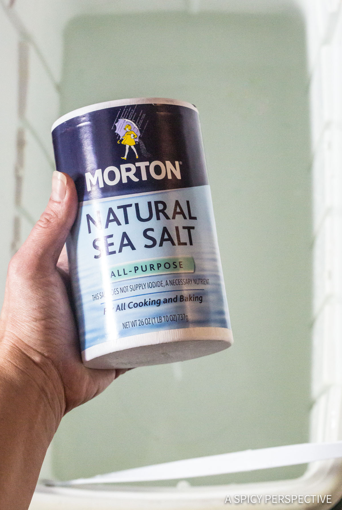 turkey-brine-spices Hand holding a container of natural sea salt for Turkey Brine Recipe.