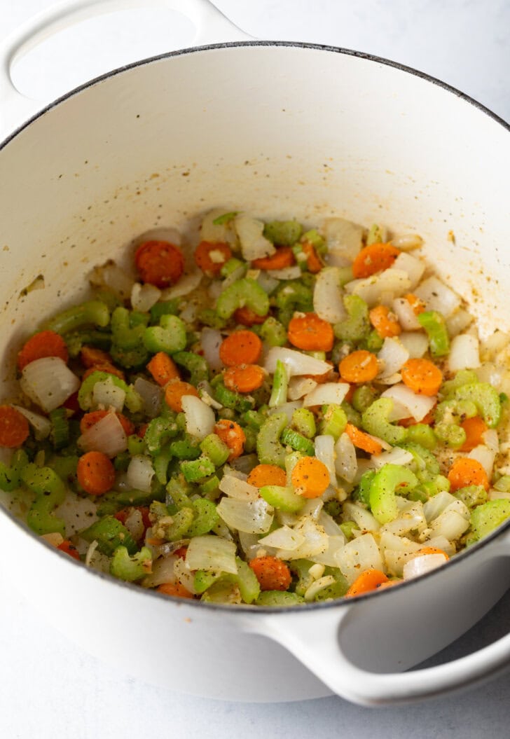 Chopped carrots, celery, and onion sautรฉing in a large pot.