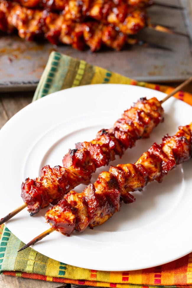 Chicken Kebab #ASpicyPerspective #Chicken #Bacon #BBQ #Chipotle #Skewers #ChickenSkewers #BBQChicken #ChickenSkewersRecipe #BBQSkewers #ChipotleChicken #Grill #Summer Chicken Kebab Recipe with bbq sauce and bacon on plate