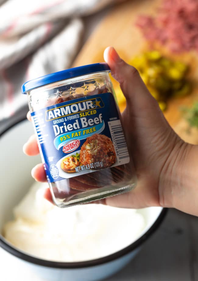 Hand holding a jar of dried beef.