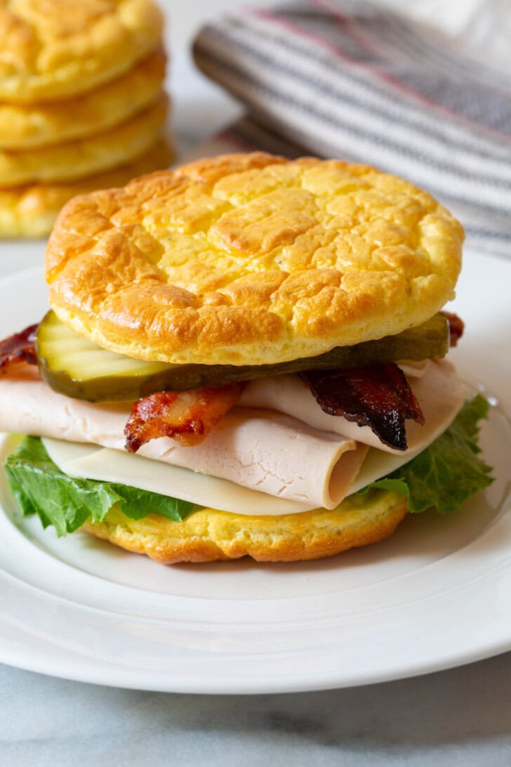 Keto Bread Recipe #ASpicyPerspective #LowCarb #GlutenFree #GrainFree #Keto #CloudBread #CloudBreadRecipe #KetoCloudBread #NoCarbBread Turkey bacon sandwich made with low carb cloud bread.