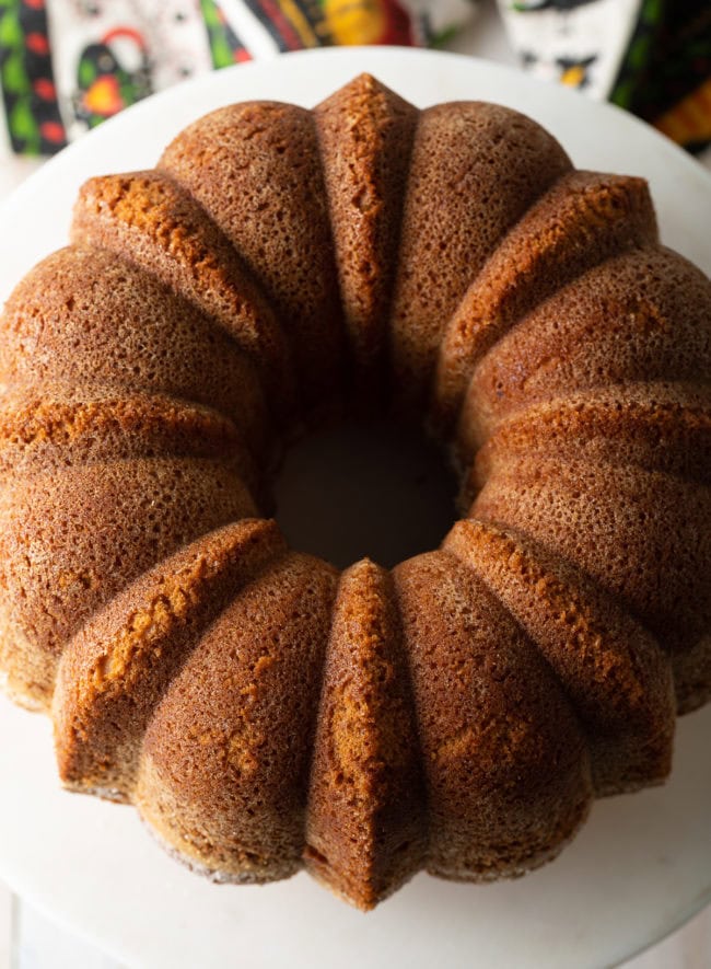 Turned out the best pound cake recipe on a cake stand showing off the curves from the bundt pan