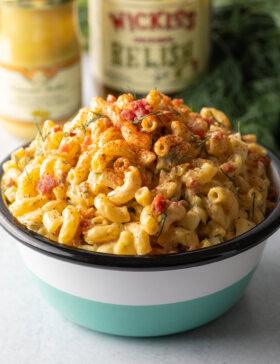 Blue, white, and black striped bowl with heaping amount of cold deviled egg pasta salad.
