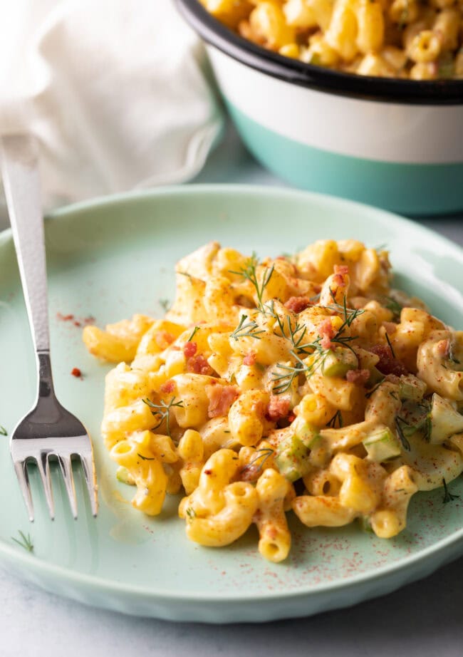 Serving of deviled egg salad on a blue plate, with metal fork on the side.
