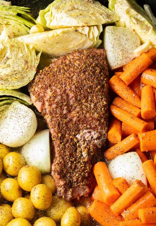 Vegetables placed around the corned beef before roasting.