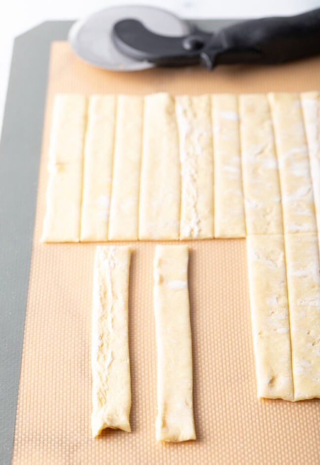 Two pieces of puff pastry slices laying side by side on baking mat.