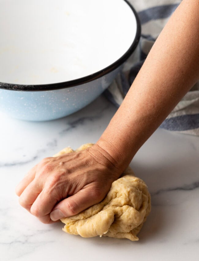 Hand kneading a ball of dough.