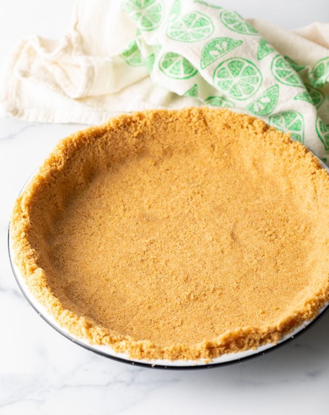 Pressed graham cracker crust mixture in a pie plate.