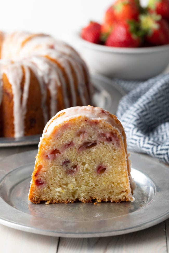 Slice of strawberry cake on a silver plate.