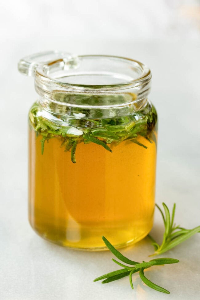 Cute little jar filled with honey and rosemary.