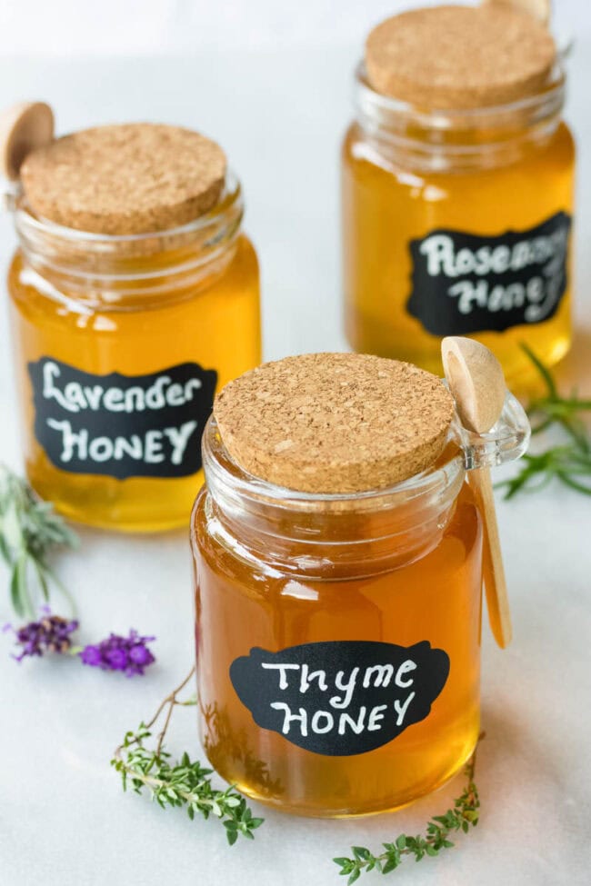 Different flavors of spiced honey in honey jars.