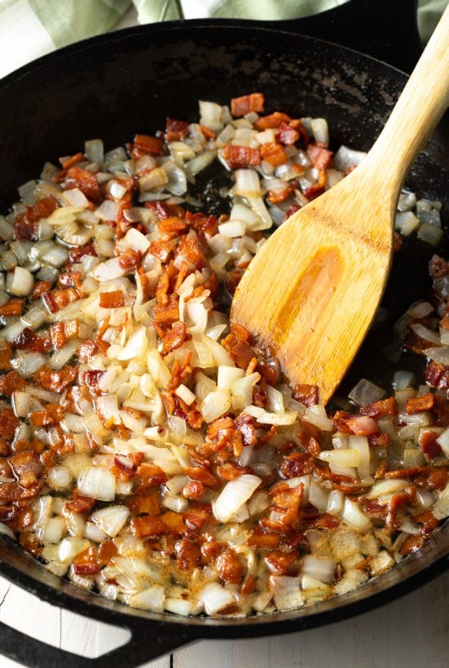 Bacon and onion sautรฉing in a pan.