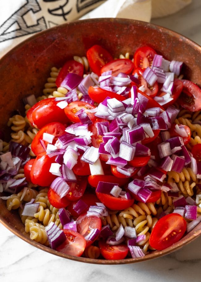 Tomatoes Onion and Pasta #ASpicyPerspective #PastaSalad #PastaSaladRecipe #ItalianPastaSalad #Italian #Salad #BestPastaSalad #Spring #Summer Pasta salad ingredients in a bowl before mixing them.