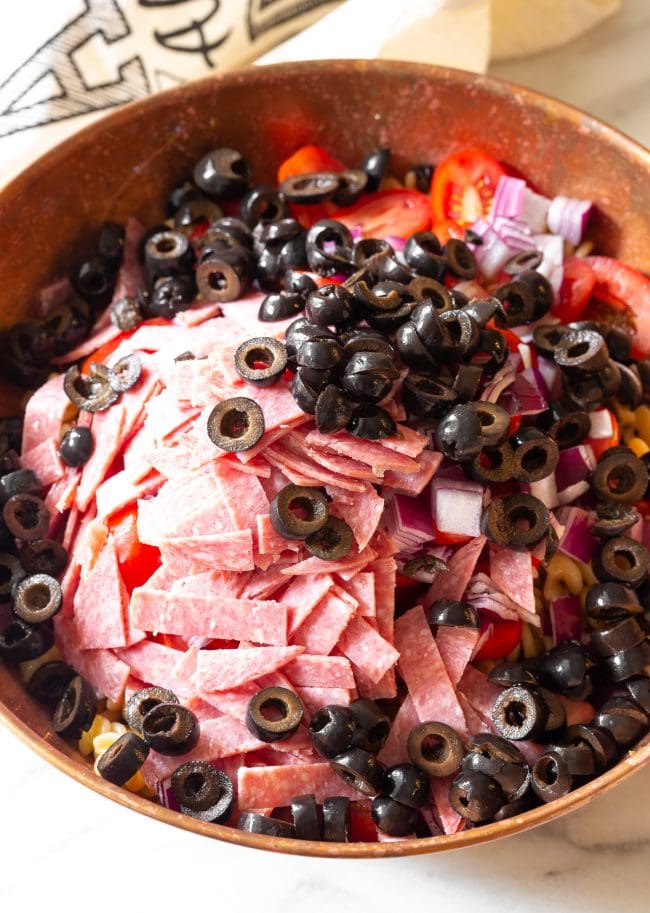Salami and Olives #ASpicyPerspective #PastaSalad #PastaSaladRecipe #ItalianPastaSalad #Italian #Salad #BestPastaSalad #Spring #Summer Italian Salad with salami and olives in a bowl.