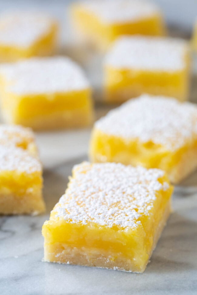 Lemon Bar Recipe #ASpicyPerspective #Lemon #Bars #LemonBars #LemonSquares #CookieCrust #WhiteChocolate #Spring #Dessert #Easter Lemon Bar Recipe - cut into lemon squares