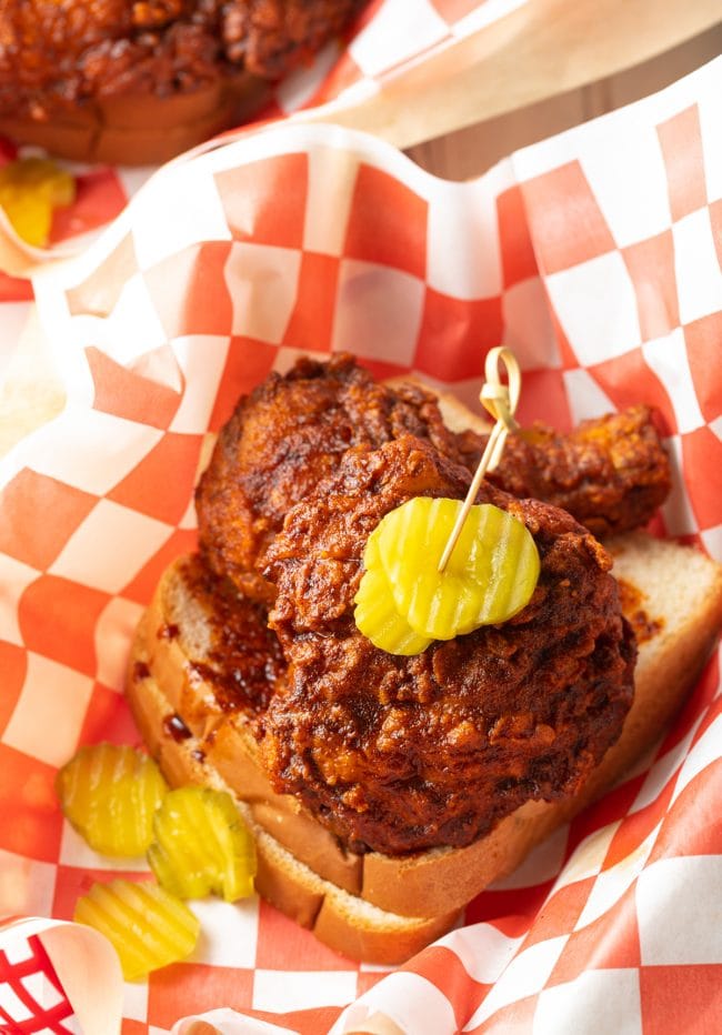 Nashville spicy fried hot chicken with pickles and bread.