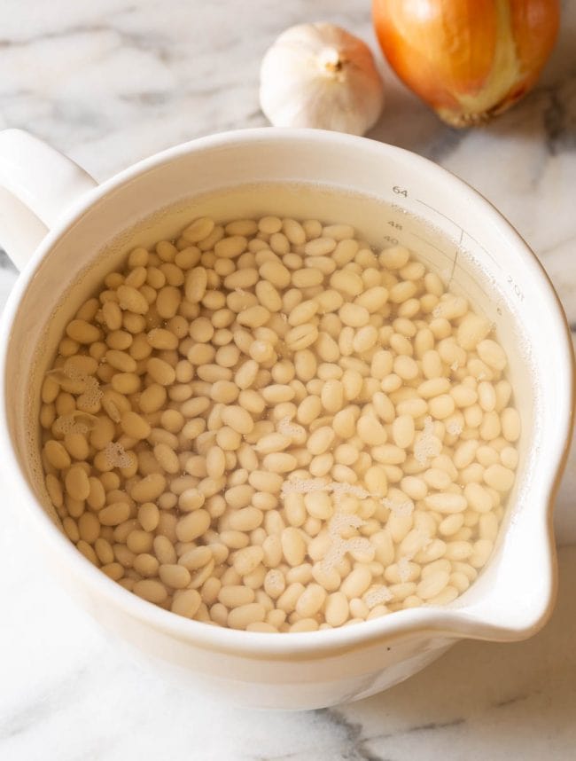 Bean Soup #ASpicyPerspective #HamAndBeanSoup #NavyBeans #HamAndBeans #NavyBeanSoup #BeanSoup #Soup A pot full of the beans soaking before making this soup