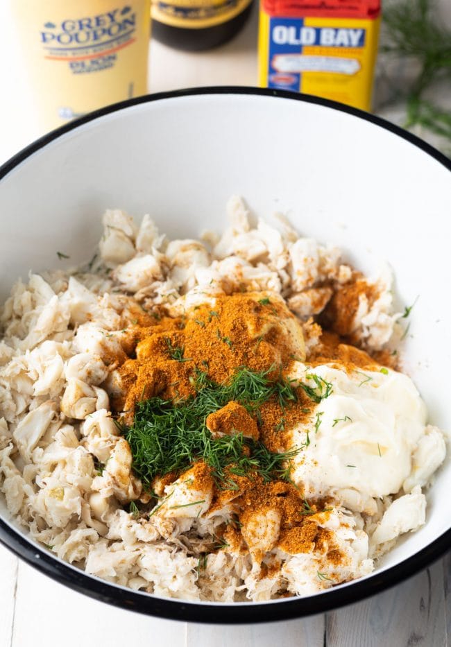 Ingredients for crab cakes in a mixing bowl before being mixed.