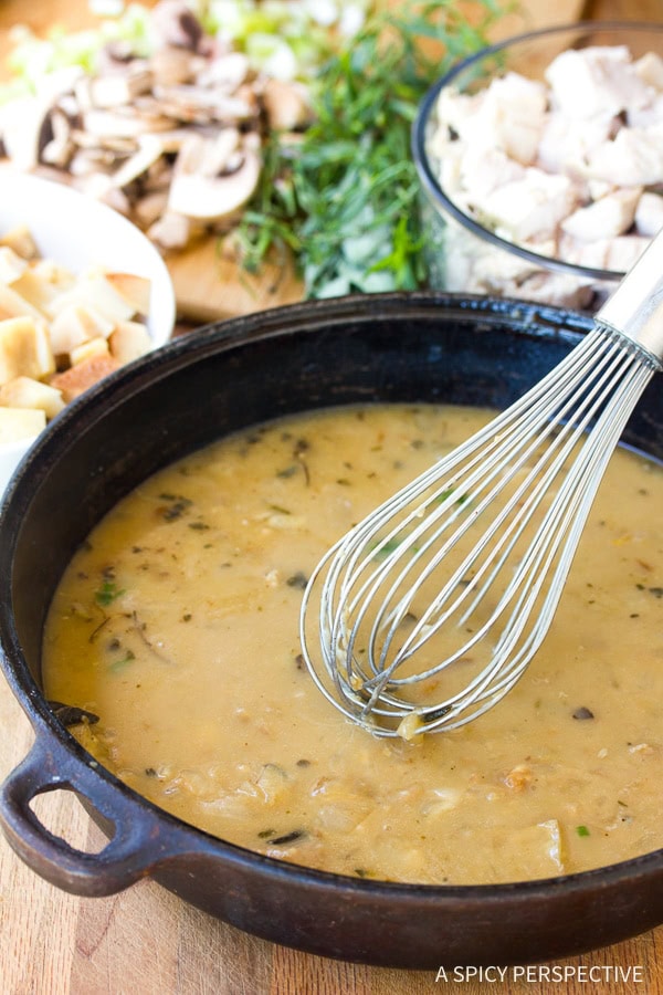 Gravy in a skillet with a whisk.