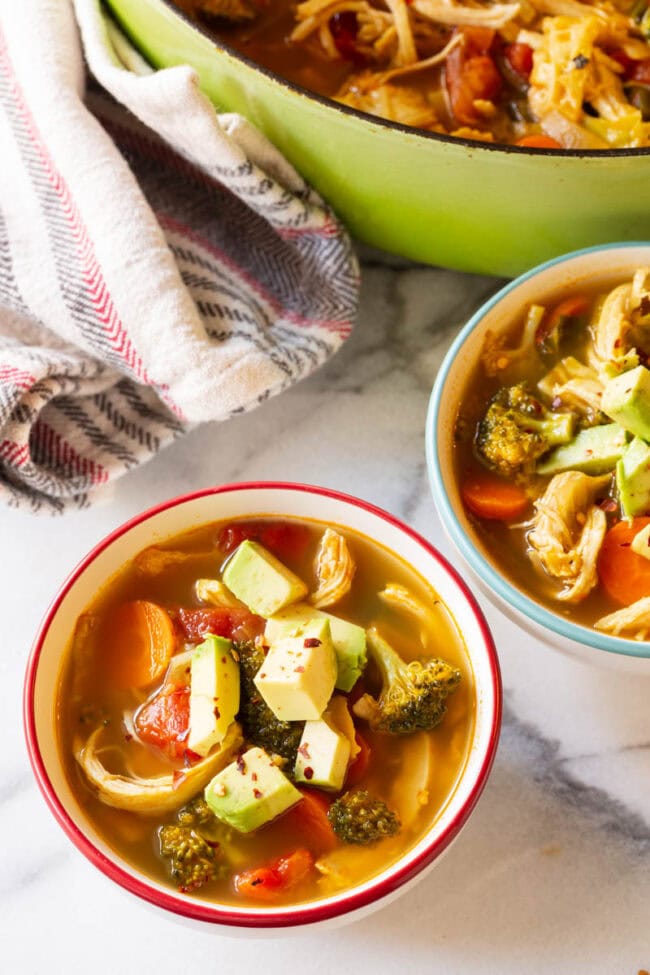 Southwest Chicken Detox Soup Recipe #ASpicyPerspective #Cleanse #Detox #Diet #Soup #Chicken Overhead bowls of low carb chicken soup topped with avocado.