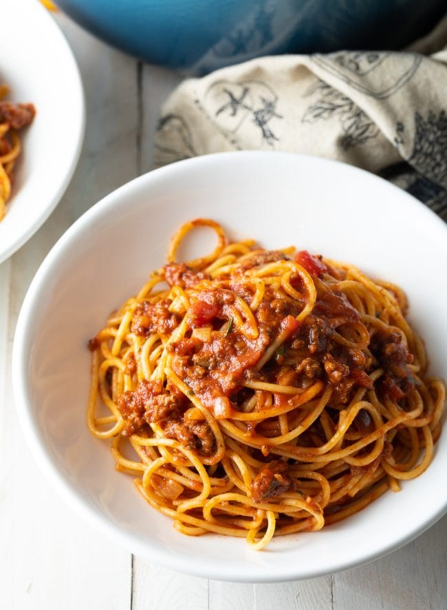 Spaghetti and meat sauce served in a white bowl.
