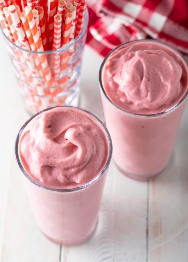 Two glasses filled with strawberry smoothie.