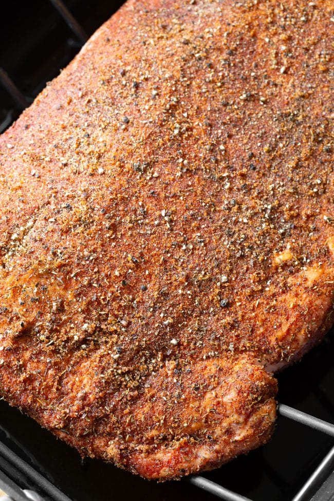 Smoked Brisket Recipe #ASpicyPerspective #Brisket #BeefBrisket #BrisketRecipe #BeefBrisketRecipe #BrisektInOven #HowtoCookBrisket #TexasStyleBrisket #LiquidSmoke #SmokedBrisketRecipe #BrisketRecipeOven Close up shot of beef brisket with dry rub on it.