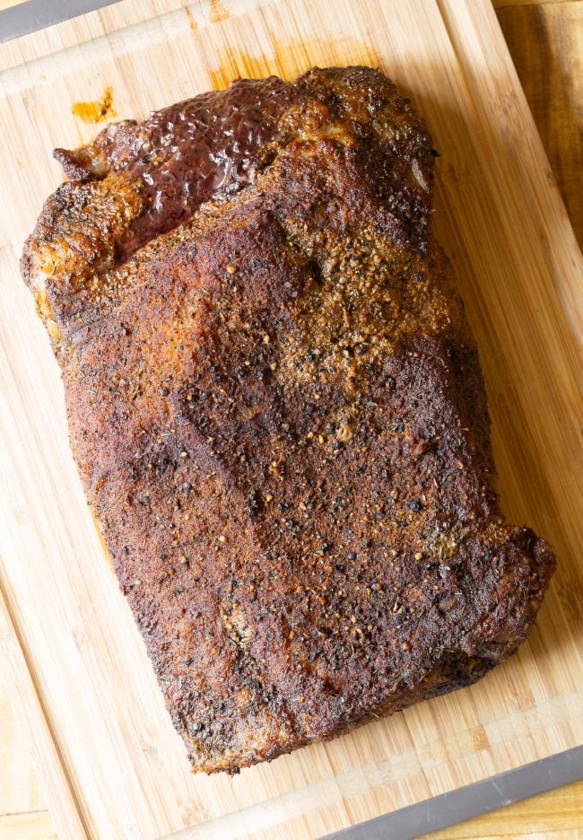 Brisket #ASpicyPerspective #Brisket #BeefBrisket #BrisketRecipe #BeefBrisketRecipe #BrisektInOven #HowtoCookBrisket #TexasStyleBrisket #LiquidSmoke #SmokedBrisketRecipe #BrisketRecipeOven Brisket after being cooked in the oven and set on a wooden cutting board.