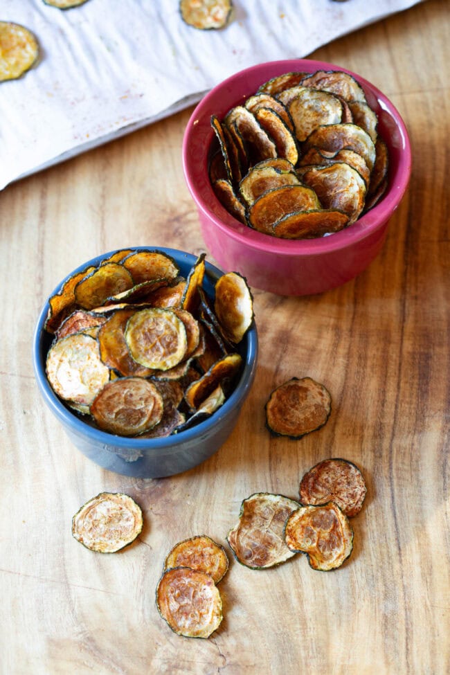 Baked Zucchini Chips #ASpicyPerspective #Healthy #Paleo #Vegan #GlutenFree #Vegetarian #ZucchiniChips #OvenRoasted Chips made from zucchini served in small bowls.